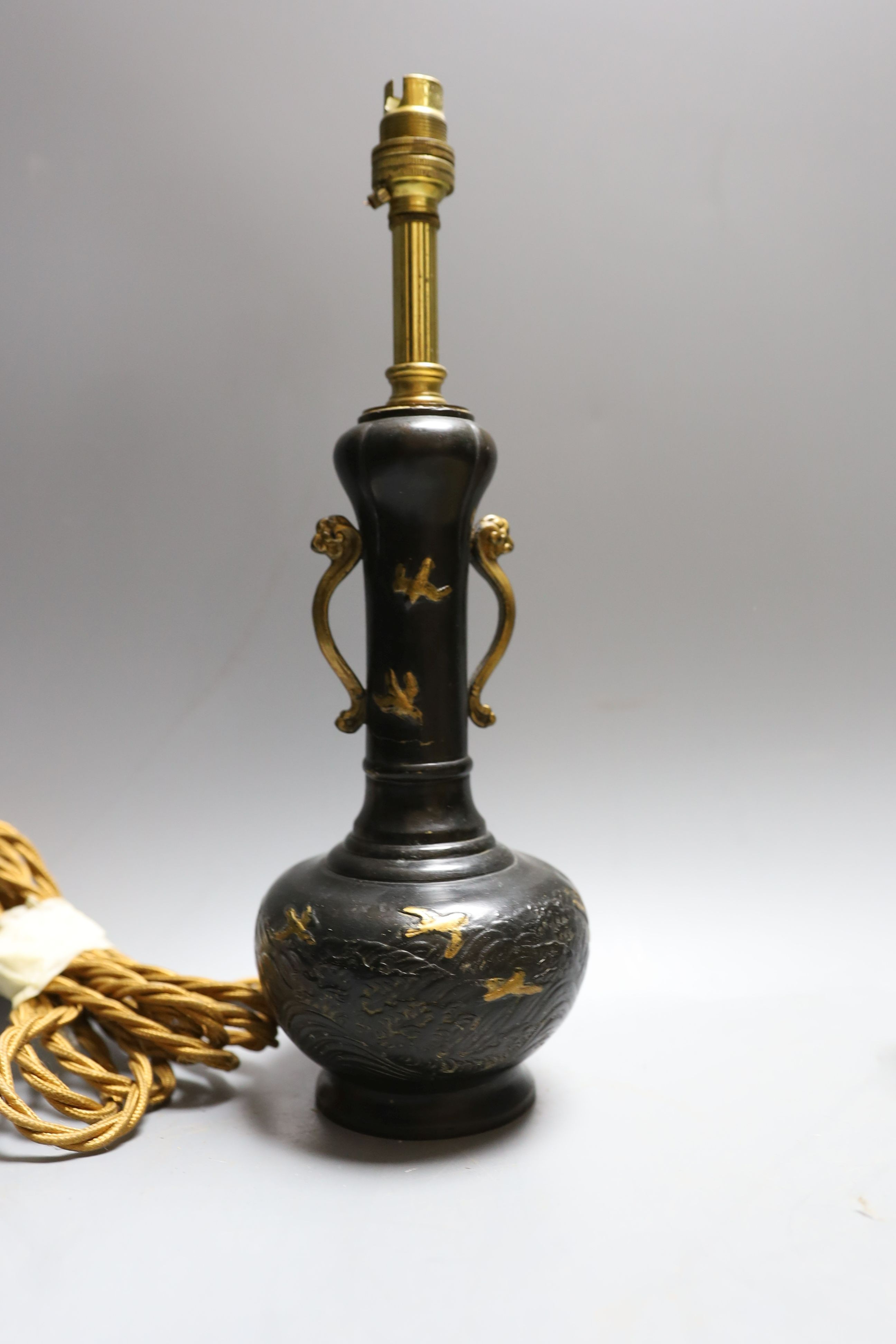 A decorative scroll brass inkstand, together with a pair of lamps, 29cm tall, (3)